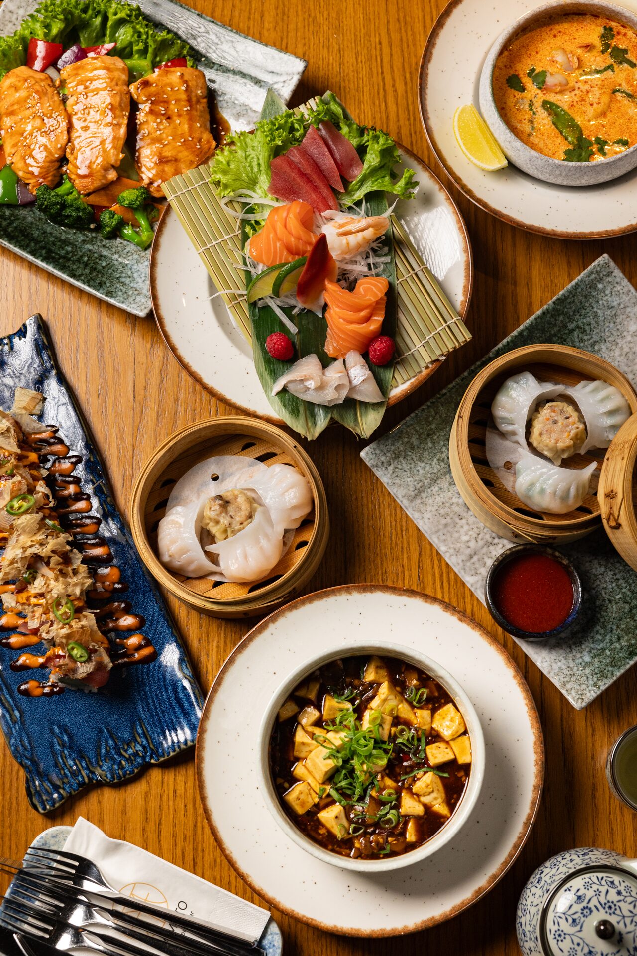 Tisch-Setting mit Sushi, Dim Sum und Wok-Gerichten