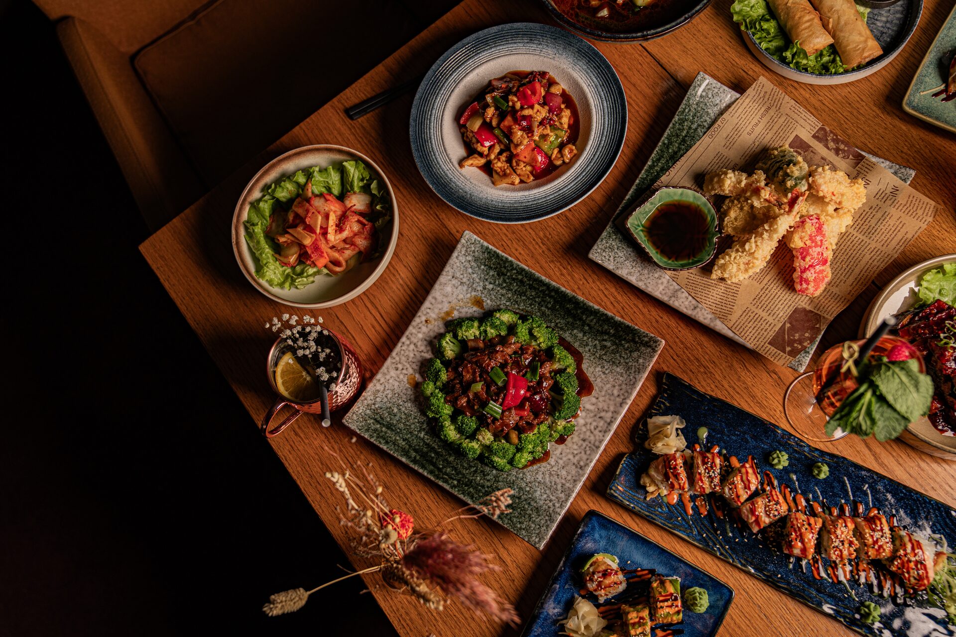Tisch-Setting mit Sushi, Wok-Gerichten und Drinks